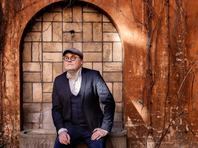 Man sidder ned og kigger forbi kameraet