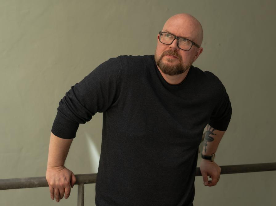 Mand der står på en trappe, ved et jerngelænder